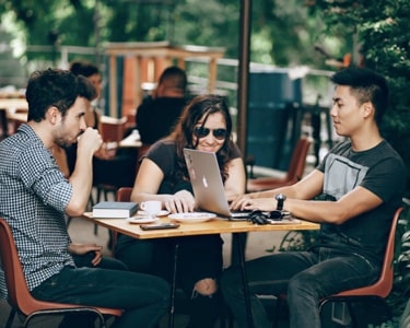 a group of payapi employees sitting around a table in a café and collaborating